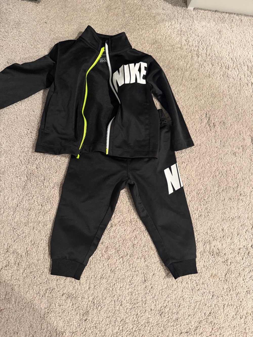 Nike Black Kids Two-Piece Tracksuit with White Logo and Neon Zipper